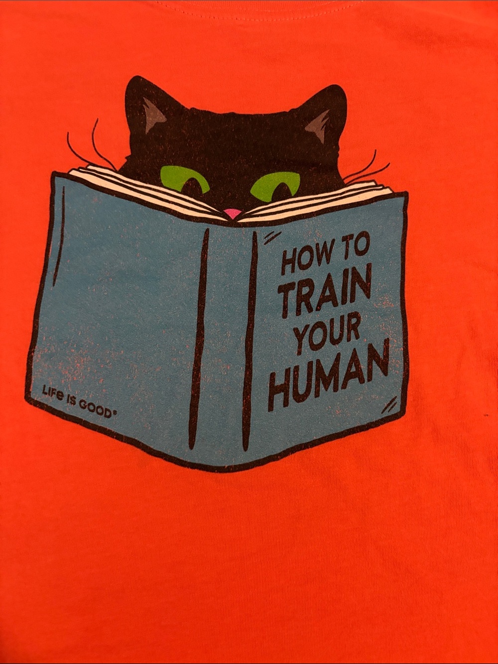 Life Is Good Orange Tee with Black Cat and Blue Book Graphic